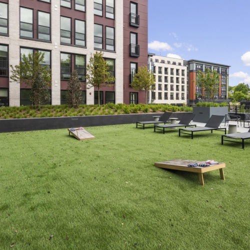 Quick access to state-of-the-art amenities a grassy area with tables and chairs in it and buildings in the background
